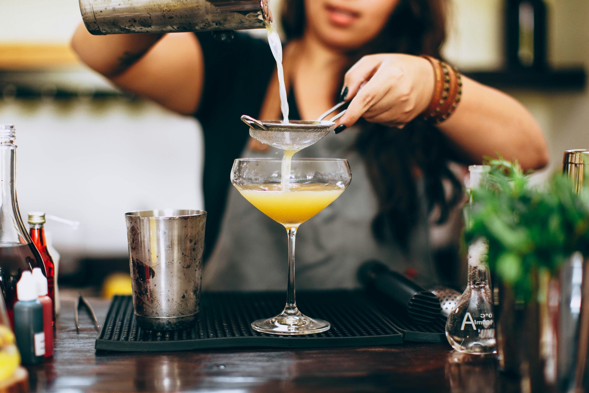 Posies bartender straining a fresh cocktail